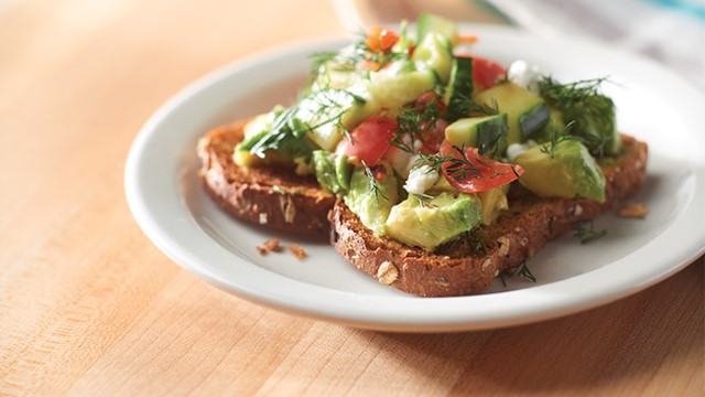 Slice of Greek avocado toast on a plate