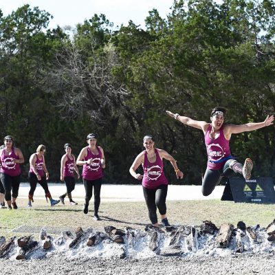 Helen Costa-Giles and her Spartan team running and jumping.