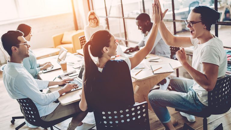 Two people high-fiving at a meeting