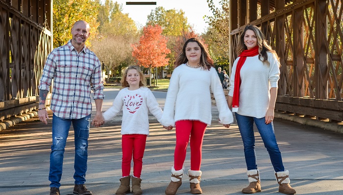 Rod Redzanic and his wife and two children holding hands