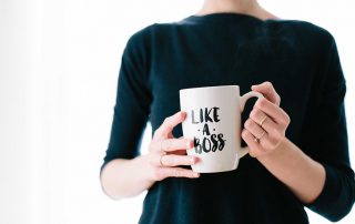 Woman holding a mug that says "LIKE A BOSS"