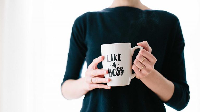 Woman holding a mug that says "LIKE A BOSS"