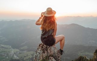 woman on top of mountain - cool hat