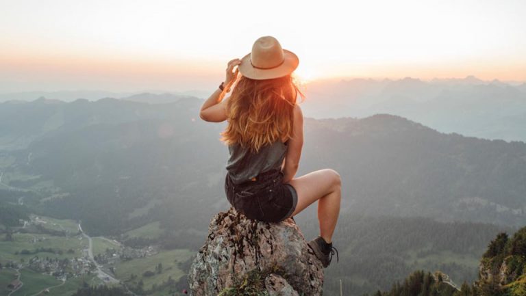 woman on top of mountain - cool hat