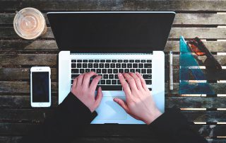 Hands typing on a laptop