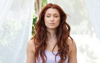 A woman meditating with her eyes closed