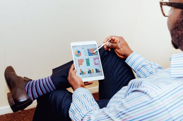 Man viewing charts and graphs on a tablet