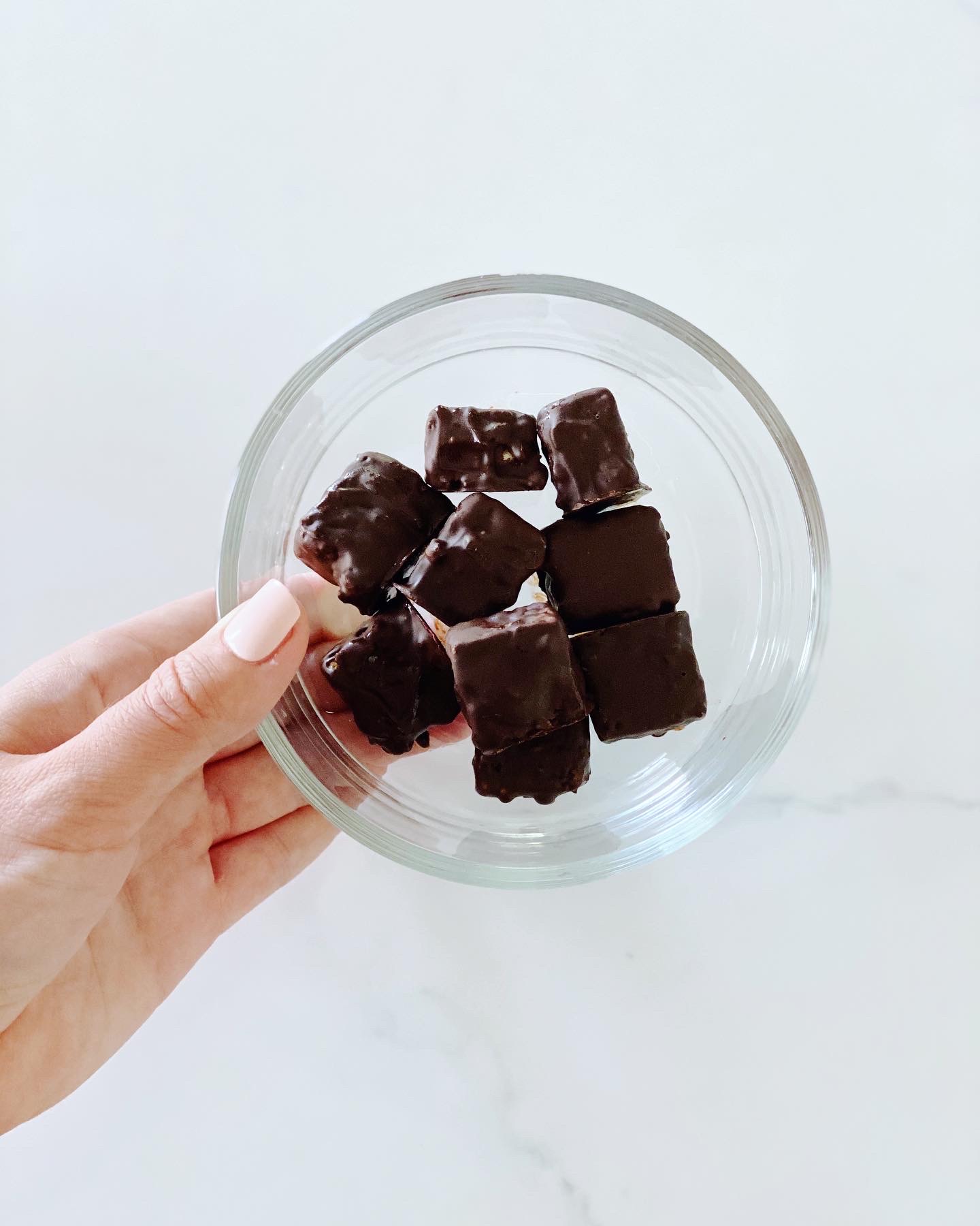 Glass bowl full of square chocolates