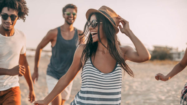 Friends in sunglasses running on the beach