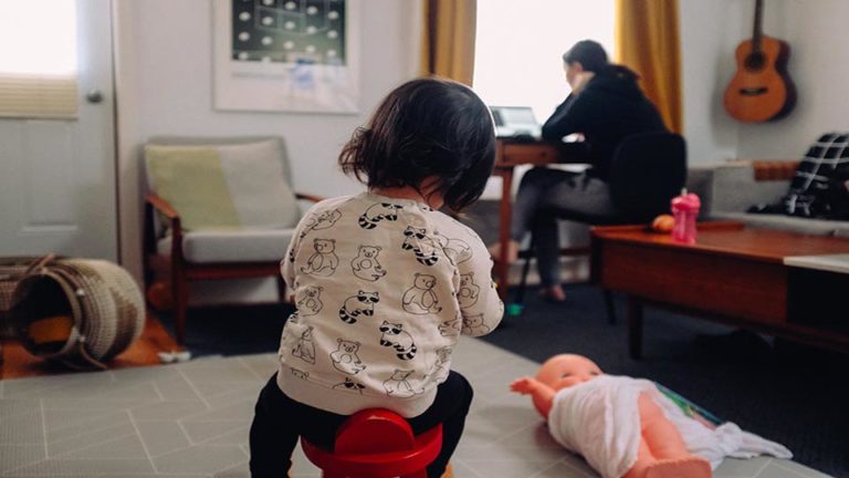 little girl playing while mom works