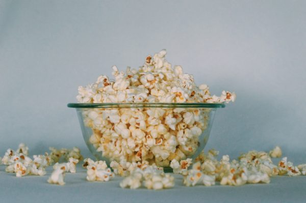 A glass bowl overflowing with popcorn