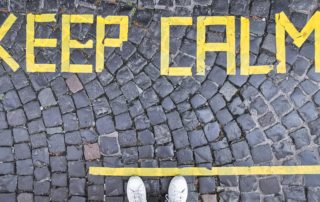 Gray cobblestone path with the words "Keep Calm" in yellow