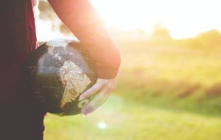 Woman holding globe by her side