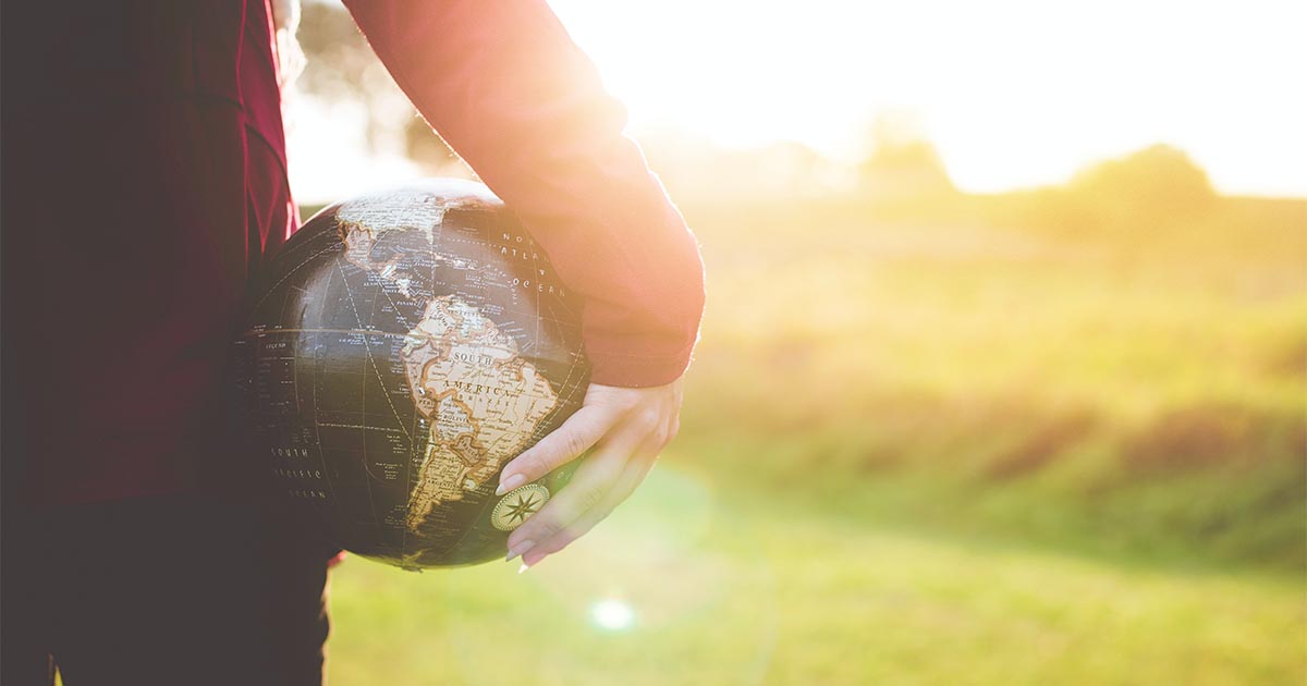 Woman holding globe by her side