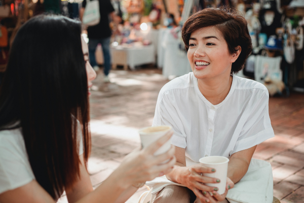 Two women enjoying coffee outside