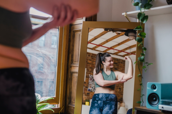 Woman flexing bicep in the mirror